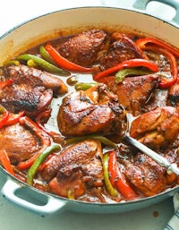 a skillet full of chicken and peppers in a sauce